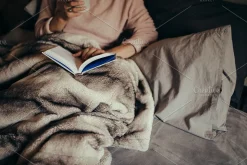 Woman on bed reading book